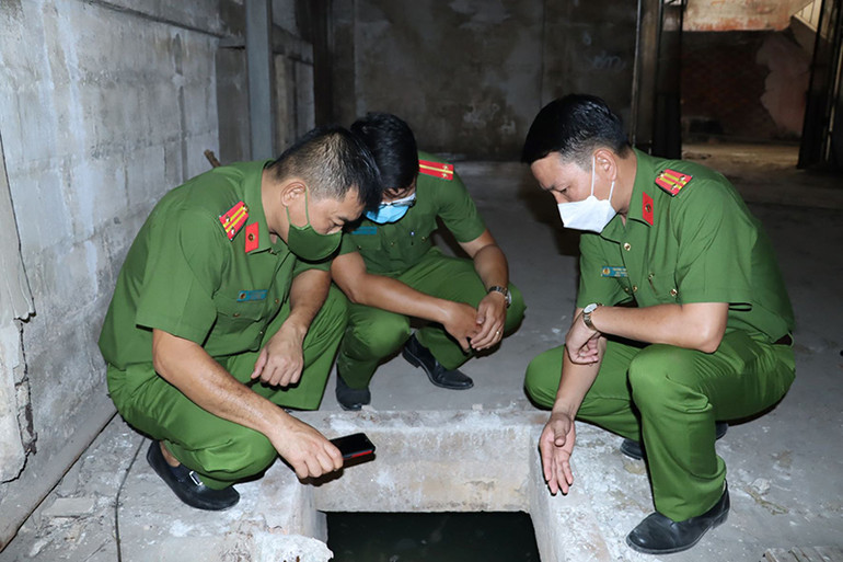 Lực lượng công an kiểm tra khu vực hầm bê-tông chứa thất thải nguy hại bên trong Xí nghiệp Đèn ống. Phát hiện hơn 42 tấn chất thải nguy hại tại doanh nghiệp bóng đèn điện quang -0