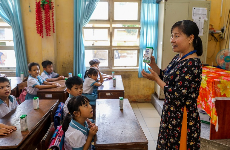 Giáo viên trường Tiểu học Thị trấn Củ Chi (TP HCM) hướng dẫn cho học sinh uống sữa học đường đúng cách vào tháng 6-2020. 24 quận, huyện tại TP Hồ Chí Minh triển khai Sữa học đường -0
