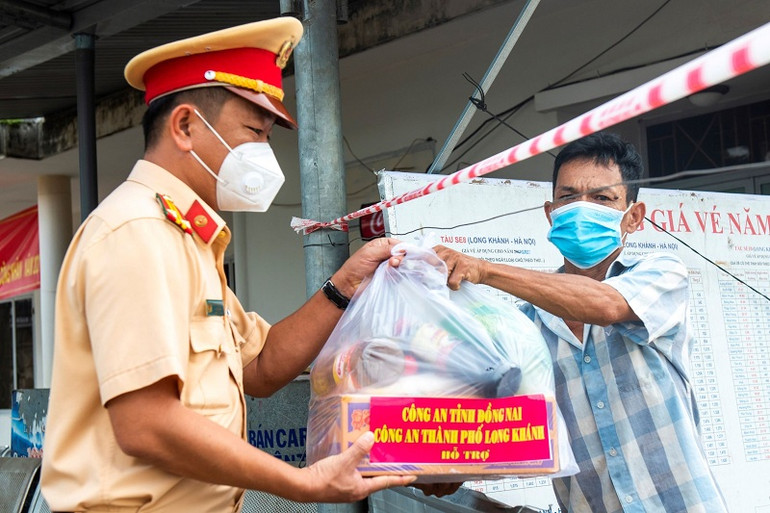 Chiến sĩ Cảnh sát giao thông Công an tỉnh Đồng Nai vào khu vực phong tỏa tặng quà cho người dân trong thời gian cao điểm dịch Covid-19 năm 2021. Công an Đồng Nai nhìn thẳng, nói thật, nghiêm túc tự chấn chỉnh -0