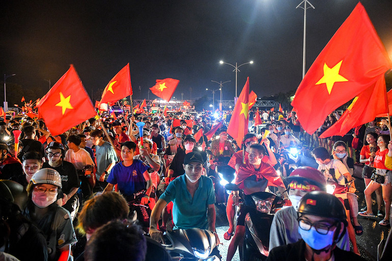 Người hâm mộ đổ ra đường hòa chung niềm vui chiến thắng với lá cờ Tổ quốc trên tay. Ảnh đẹp SEA Games 31: Rừng cờ đỏ sao vàng - Niềm tự hào dân tộc tại SEA Games 31 -0