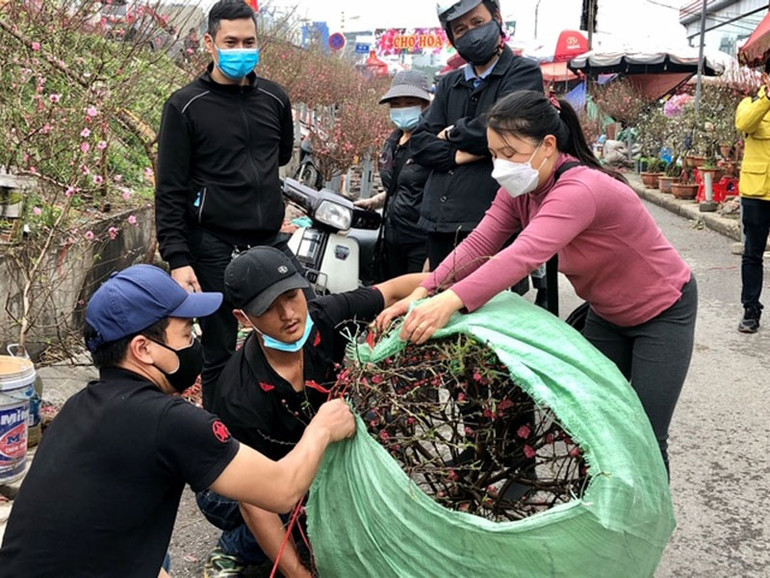 Một số người bán tại chợ hoa Quảng An đeo khẩu trang không đúng quy định. Kiểm tra hoạt động chợ hoa Xuân tại Hà Nội -0