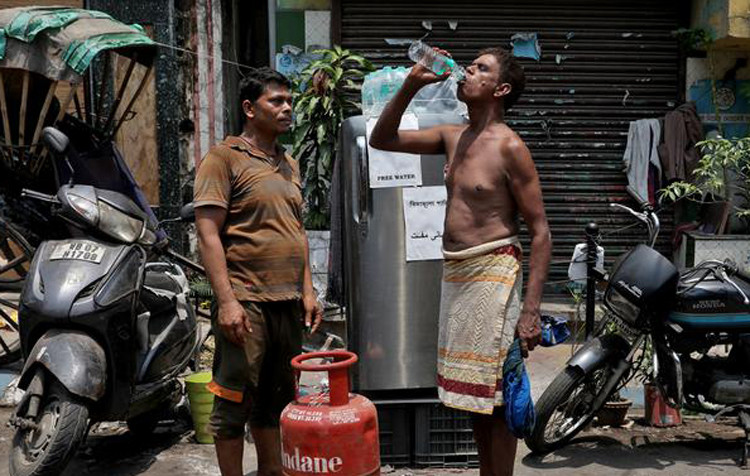 Người dân Calcutta chia sẻ nước mát với người qua đường. (Ảnh: Reuters) Hình ảnh người dân Ấn Độ nhọc nhằn trong nắng nóng ngột ngạt -0