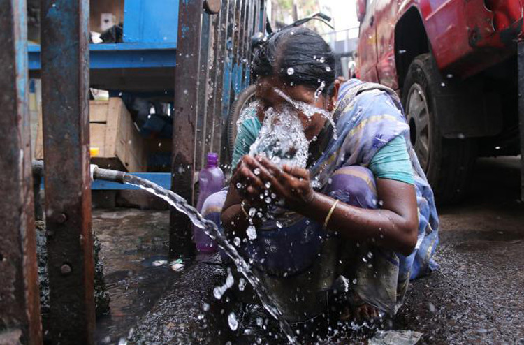 Một phụ nữ vẩy nước lên mặt để giảm nhiệt tại Kolkata. (Ảnh: CNN) Hình ảnh người dân Ấn Độ nhọc nhằn trong nắng nóng ngột ngạt -0