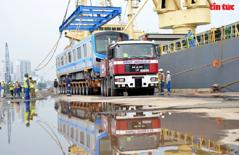 Bốc dỡ toa tàu xuống xe siêu trường. (Ảnh: TTXVN) Bốn đoàn tàu của tuyến metro Bến Thành-Suối Tiên về đến Việt Nam -0