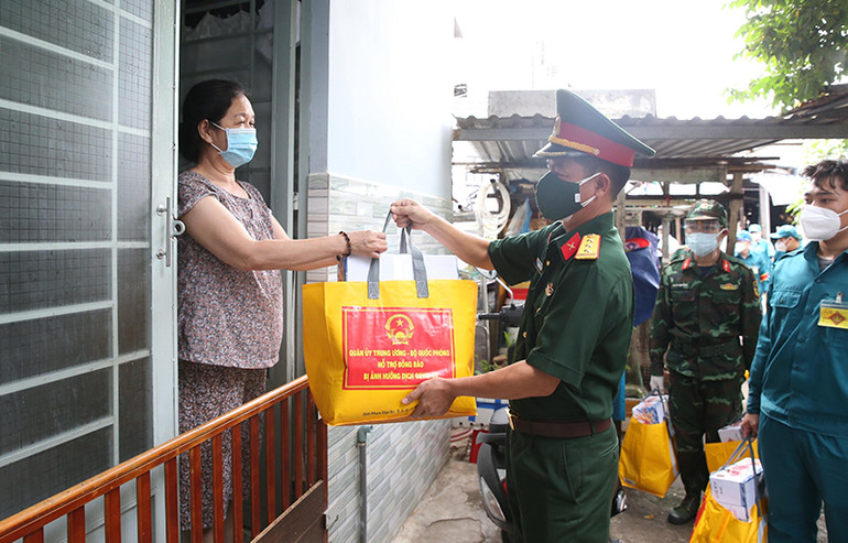 Cán bộ, chiến sĩ Quân đội trao quà hỗ trợ các gia đình gặp khó khăn do dịch Covid-19 tại quận 8, TP Hồ Chí Minh. Ảnh: Hồng Pha Bộ đội thời bình -0