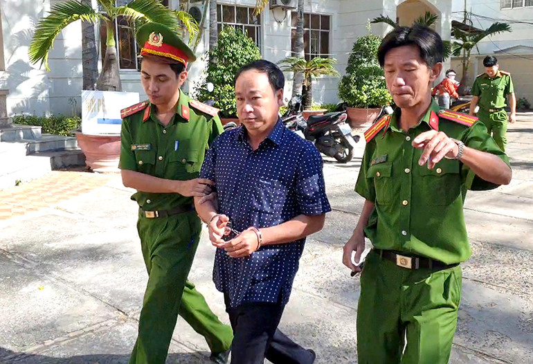 Cơ quan Cảnh sát điều tra Công an tỉnh Bình Thuận dẫn giải bị can Nguyễn Hữu Hoành (áo sơ mi) từ nơi làm việc về nơi giam giữ. Khởi tố năm bị can liên quan đến vi phạm đất đai tại TP Phan Thiết -0