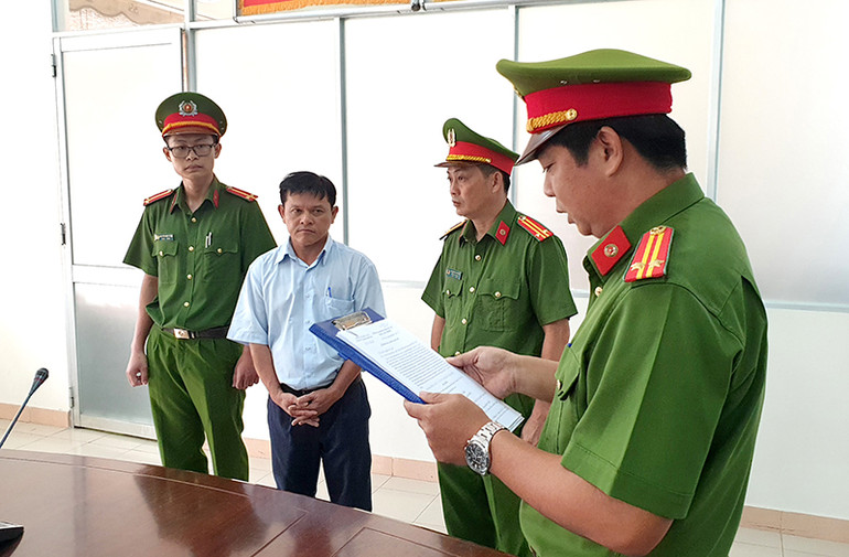 Cơ quan Cảnh sát điều tra Công an tỉnh Bình Thuận đọc Quyết định khởi tố bị can, Lệnh bắt tạm giam đối với Nguyễn Ngọc Quang (áo trắng) tại nơi làm việc. Khởi tố năm bị can liên quan đến vi phạm đất đai tại TP Phan Thiết -0