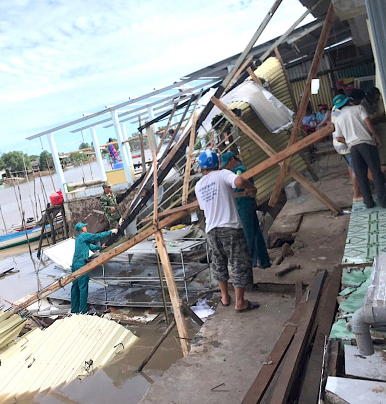Lực lượng chức năng giúp dân thu dọn đống đổ nát sau vụ sạt lở khu vực chợ Kênh 17. Sạt lở nhấn chìm 14 nhà dân miệt sông nước Cà Mau -0