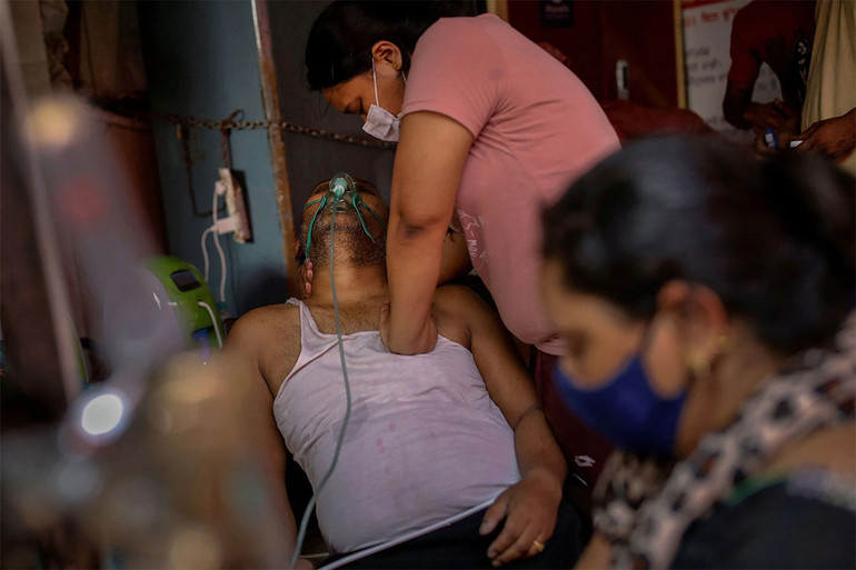 Manisha Bashu ấn mạnh vào ngực của bố khi ông đang bị khó thở. Trước đó, bố của Manisha Bashu đã rơi vào trạng thái bất tỉnh khi đang được hỗ trợ oxy trong bối cảnh Covid-19 lây lan tại TP Ghaziabad, ngày 30/4/2021. (Ảnh: REUTERS/Adnan Abidi) Loạt ảnh về đại dịch Covid-19 tại Ấn Độ của Reuters giành giải Pulitzer 2022 -0