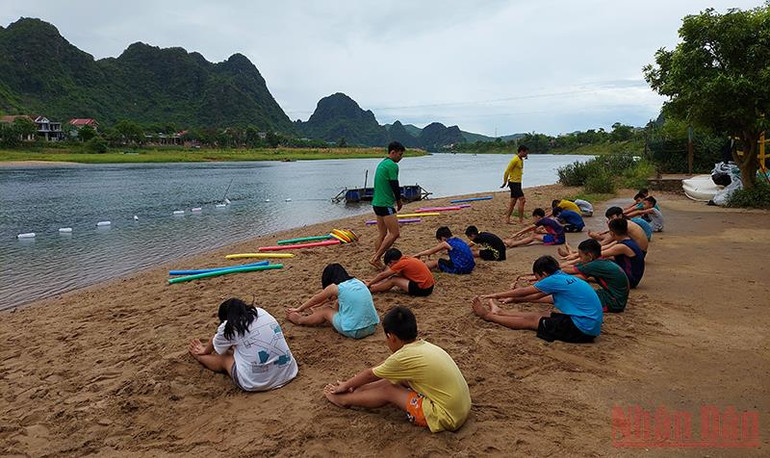 Giáo viên là các nhân viên về du lịch mạo hiểm của Oxalis Adventure hướng dẫn các em khởi động trước khi xuống nước. Quảng Bình dạy bơi miễn phí cho trẻ em -0