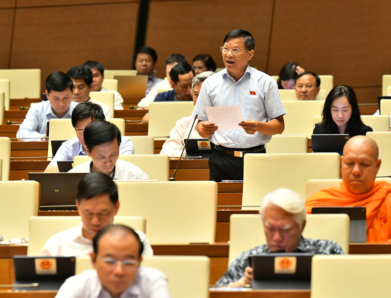 Đại biểu Trần Văn Tiến (Vĩnh Phúc) phát biểu tại hội trường, chiều 6/6. (Ảnh: LINH NGUYÊN) Bộ trưởng Giao thông vận tải lý giải nguyên nhân chậm tiến độ dự án đường Hồ Chí Minh -0
