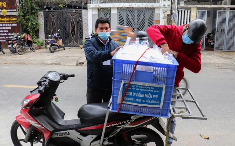 Anh Nguyễn Duy Đức (trái), Chủ nhiệm quán cơm Yên Vui hỗ trợ chuẩn bị mang cơm đến những điểm bán lưu động. Cơm Yên Vui chia sẻ tình người -0
