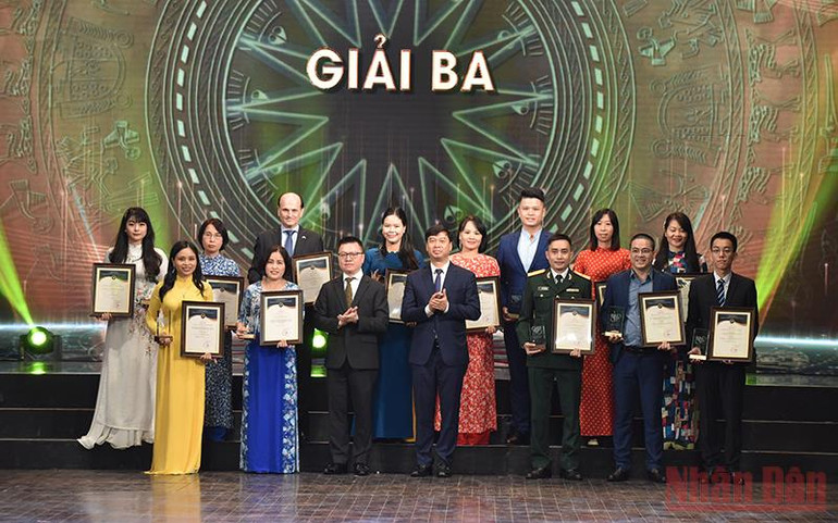 Đồng chí Lê Quốc Minh, Ủy viên Trung ương Đảng, Tổng Biên tập Báo Nhân Dân, Phó Trưởng Ban Ban Tuyên giáo Trung ương, Chủ tịch Hội Nhà báo Việt Nam và đồng chí Ngô Minh Hiển, Phó Tổng Giám đốc Đài tiếng nói Việt Nam trao giải Ba cho các tác giả đoạt giải. (Ảnh: TRẦN HẢI) Lễ trao Giải thưởng toàn quốc về thông tin đối ngoại lần thứ VII -0