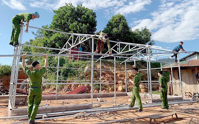 Chiến sĩ Công an huyện Mường Nhé (Ðiện Biên) giúp hộ nghèo ở bản Huổi Hốc, xã Nậm Kè làm nhà mới. Ảnh: LÊ LAN Xây nhà mới cho hộ dân nghèo -0