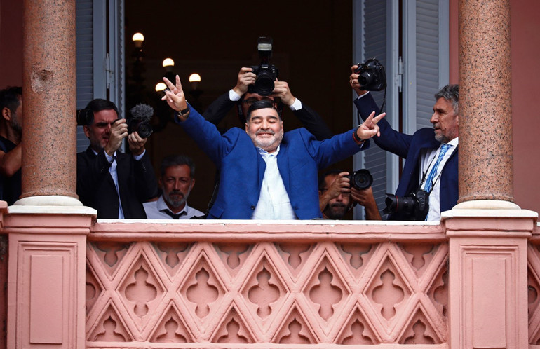Maradona chào người hâm mộ bên ngoài Văn phòng Chính phủ Argentina sau khi ông gặp Tổng thống Alberto Fernandez, năm 2019. (Ảnh: AP) Cuộc đời và sự nghiệp của huyền thoại Maradona qua ảnh -0