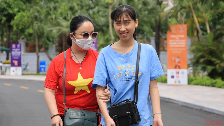 Cặp đôi cổ động viên đặc biệt dắt tay nhau tới nhà thi đấu Tây Hồ. Cổ động viên đặc biệt: Đến sân, “xem” SEA Games bằng… đôi tai -0