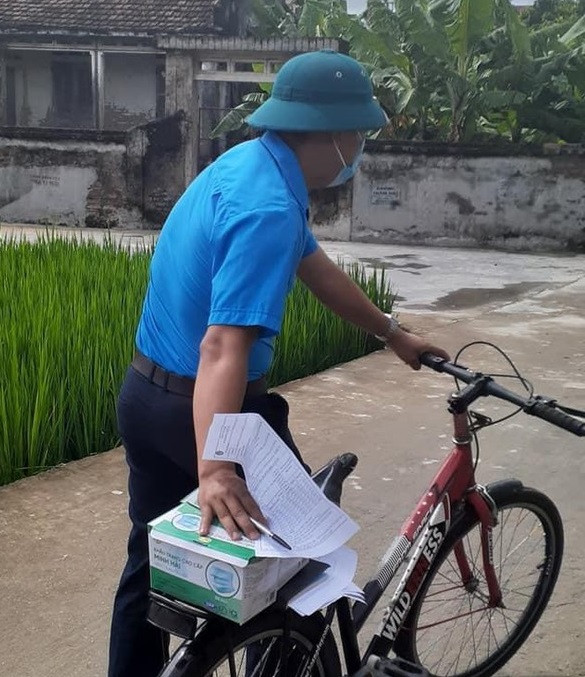 Một thanh niên tình nguyện ở Hải Dương đang đi xe đạp đến từng nhà dân tuyên truyền cài đặt Bluezone. Thấm đẫm màu áo xanh tình nguyện trong chiến dịch vận động cài Bluezone -0