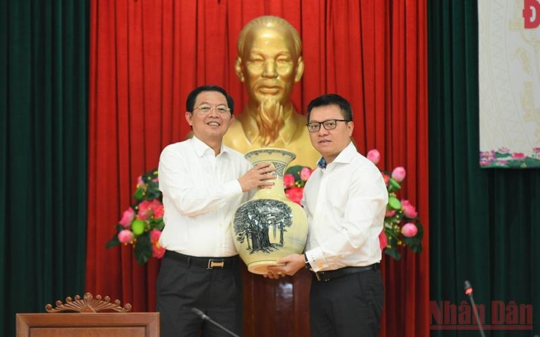 Đồng chí Lê Quốc Minh, Ủy viên Trung ương Đảng, Tổng Biên tập Báo Nhân Dân tặng quà lưu niệm cho Tỉnh ủy Bình Định. (Ảnh: Thành Đạt) anh_1_5-1656331523191.jpg