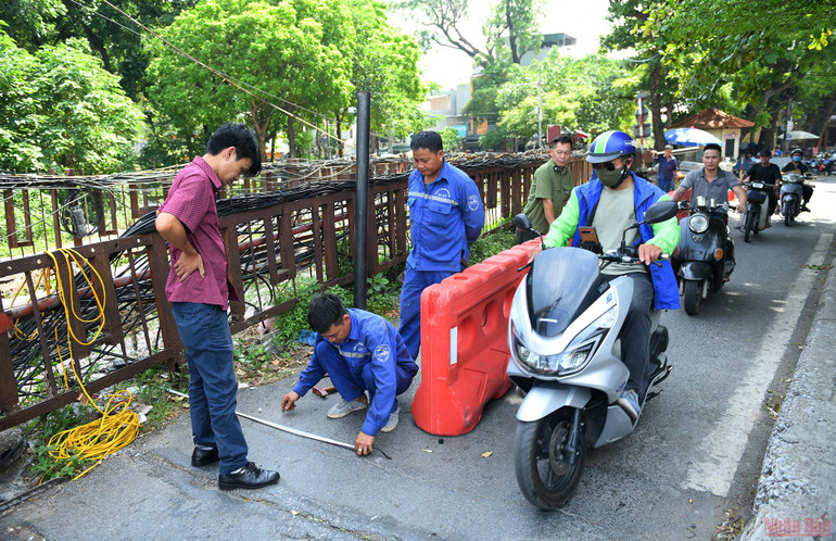 Sáng 22/6, nhân viên Công ty Cổ phần đường sắt Hải Hà - đơn vị quản lý, duy tu cầu Long Biên đã tiến hành đo đạc để lắp cột chắn ngăn ô-tô và xe ba gác tải nặng đi lên cầu. Lắp rào chắn bảo vệ cầu Long Biên -0