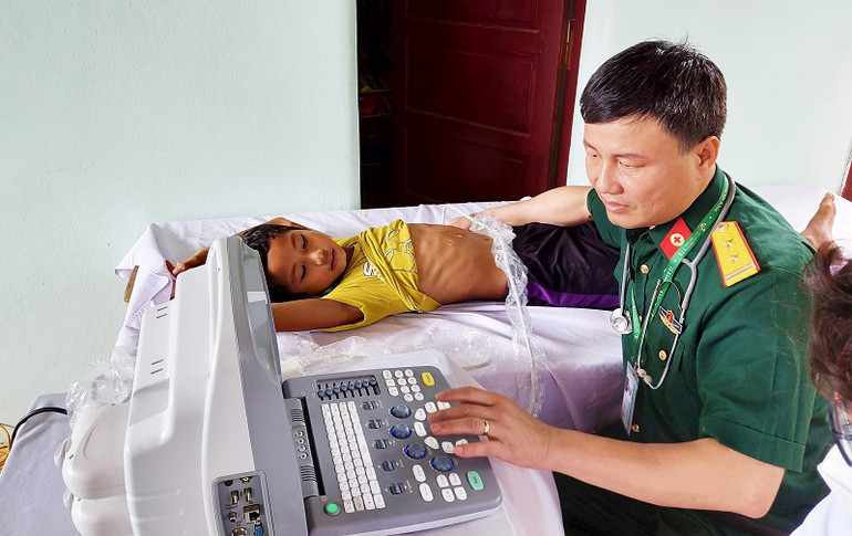 Bác sĩ, Trung tá Nguyễn Xuân Thành siêu âm cho bệnh nhi là người dân tộc thiểu số. Khám bệnh, tặng quà gia đình chính sách, hộ nghèo tại Quảng Bình -0
