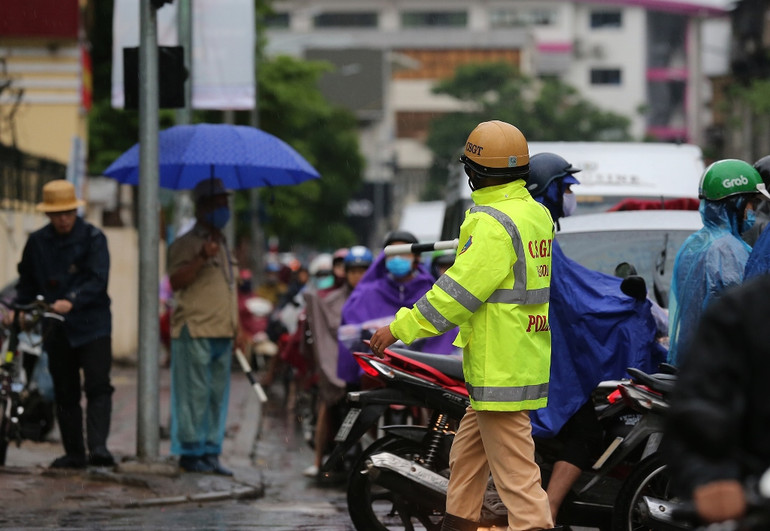 Lực lượng cảnh sát giao thông vất vả phân luồng nhưng không thể giảm ùn tắc. Hà Nội mưa lớn, ùn tắc nghiêm trọng sáng đầu tuần -0