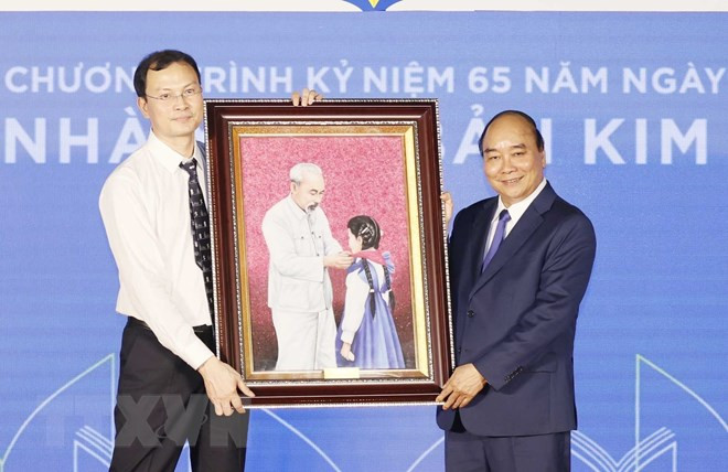 Chủ tịch nước tặng bức tranh "Bác Hồ với thiếu nhi" cho Nhà xuất bản Kim Đồng. (Ảnh: TTXVN) Chủ tịch nước dự kỷ niệm 65 năm thành lập Nhà xuất bản Kim Đồng -0