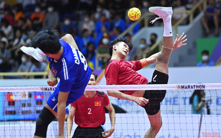Pha tấn công trên lưới của cầu thủ số 7 đội Việt Nam (áo đỏ) trước sự truy cản quyết liệt của đội Campuchia (áo xanh). Những pha bóng đẹp môn Cầu mây trong trận đấu đồng đội 3 người nam giữa Việt Nam và Campuchia -0