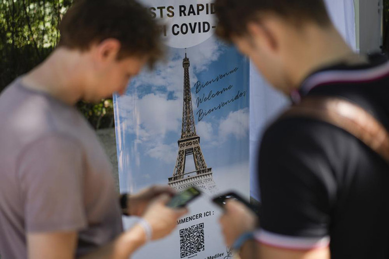 Du khách quét mã QR khai báo thông tin về Covid-19 tại điểm thăm quan nổi tiếng Tháp Eiffel ở Paris hôm 21/7 (Ảnh: AP) Châu Âu nỗ lực cứu vãn mùa du lịch hè -0