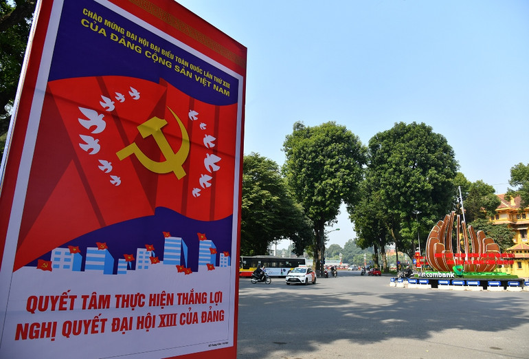 Bên cạnh hoa và cây cảnh, những tấm pano, áp phích khổ lớn được lắp đặt tại các tuyến phố như: Bà Triệu, Hàng Bài, Phan Đình Phùng, Điện Biên Phủ, Thanh Niên, Nguyễn Chí Thanh, Phạm Hùng… Hà Nội rực rỡ cờ hoa chào mừng Đại hội lần thứ XIII của Đảng -0
