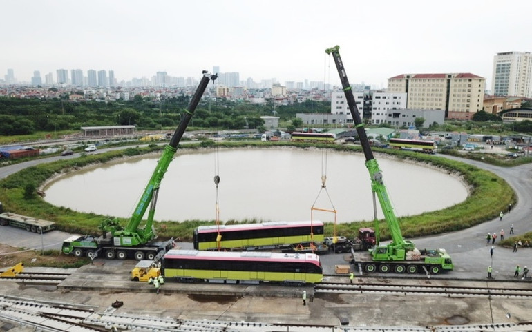 Hai chiếc cẩu cỡ lớn hoạt động hết công suất để đưa các toa tàu lên ray. metro3-1603164081432.jpg