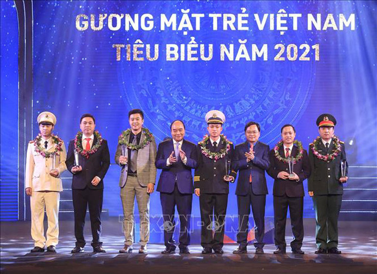 Chủ tịch nước Nguyễn Xuân Phúc và Bí thư thứ nhất Trung ương Đoàn Nguyễn Anh Tuấn trao biểu trưng tuyên dương các Gương mặt trẻ Việt Nam tiêu biểu năm 2021. (Ảnh: Thống Nhất/TTXVN) Chủ tịch nước dự Lễ trao giải “Gương mặt trẻ Việt Nam tiêu biểu năm 2021” -1