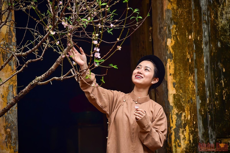 Thiếu nữ bên cành đào báo hiệu mùa Xuân đang đến. (Ảnh: Thành Đạt) Tái hiện hình ảnh Tết xưa – lưu giữ những giá trị truyền thống tốt đẹp -0
