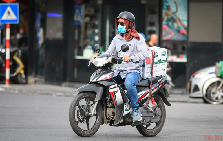 Để chống chọi với cái nắng như đổ lửa này, người dân Thủ đô ra đường với “thời trang” kín mít toàn thân, thậm chí quấn cả khăn lên đầu để bớt nóng. Người dân Hà Nội chống chọi với nắng nóng gay gắt -0