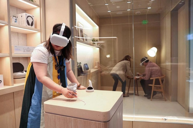 Yuxi Wang, giám đốc tiếp thị sản phẩm tại Meta, trình diễn sử dụng kính thực tế ảo Oculus trong buổi preview cửa hàng ngày 4/5. (Ảnh: Reuters) Những hình ảnh đầu tiên về cửa hàng bán lẻ thiết bị thực tế ảo của Meta -0
