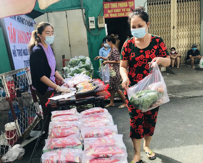 Người dân trong khu vực cách ly nhận các nhu yếu phẩm từ gian hàng 0 đồng tại phường Tân Thành, quận Tân Phú. Dịch khó càng không thể bỏ nhau -0