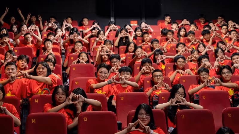 Các thầy cô giáo và học sinh Trường trung học cơ sở và trung học phổ thông Lương Thế Vinh tại rạp chiếu để đón chờ xem phim "Mưa đỏ".