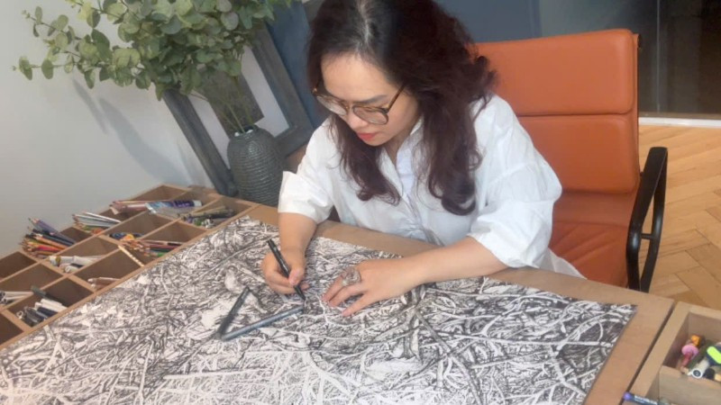 Họa sĩ Hoàng Thị Thu Hà miệt mài bên tác phẩm.