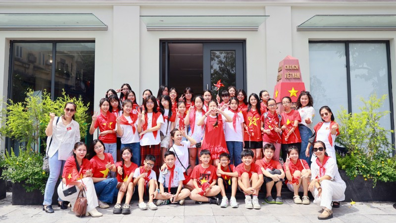 Các em học sinh chụp ảnh lưu niệm tại mô hình cột mốc Trường Sa ở Trung tâm Thông tin văn hóa Hồ Gươm.