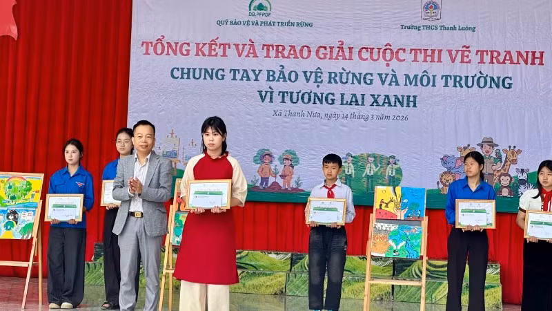 Ông Trần Xuân Tâm, Phó Giám giám đốc Quỹ Bảo vệ và Phát triển rừng tỉnh Điện Biên, trao giải Nhất cuộc thi cho em Mai Thùy Chi, lớp 8C1 Trường Trung học cơ sở Thanh Luông.