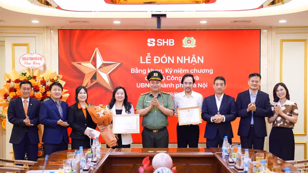 Đại tá Nguyễn Tiến Đạt, Phó Giám đốc Công an TP Hà Nội trao bằng khen và công nhận tới đại diện lãnh đạo SHB.