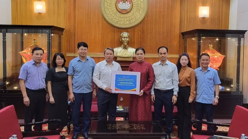Đại diện lãnh đạo Bộ Tư pháp trao tiền ủng hộ cho đồng bào bị bão lũ