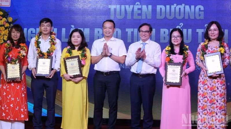 Phó Chủ tịch Ủy ban nhân dân tỉnh Đồng Nai Nguyễn Sơn Hùng và Phó Vụ trưởng, Phó trưởng Cơ quan đại diện Báo Nhân Dân tại khu vực miền nam An Văn Quang trao tặng danh hiệu nhà báo tiêu biểu tỉnh Đồng Nai.