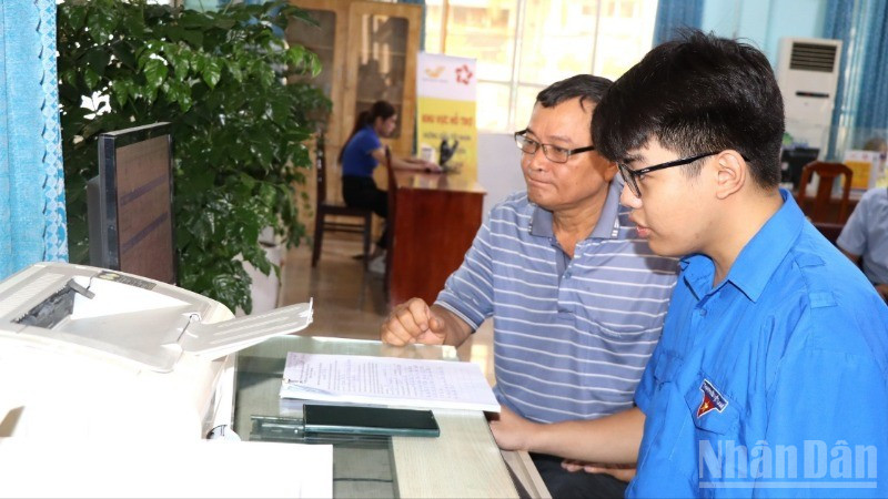 Ông Nguyễn Minh Trí được tình nguyện viên Tỉnh đoàn Đồng Nai hỗ trợ nộp hồ sơ trực tuyến.