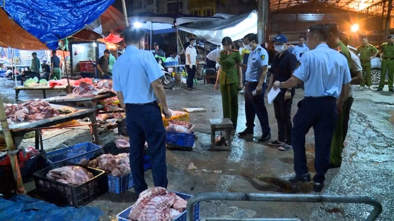 Lực lượng chức năng kiểm tra kiot kinh doanh thịt lợn "bẩn" tại khu vực chợ Phùng Khoang. (Ảnh: Công an thành phố Hà Nội)