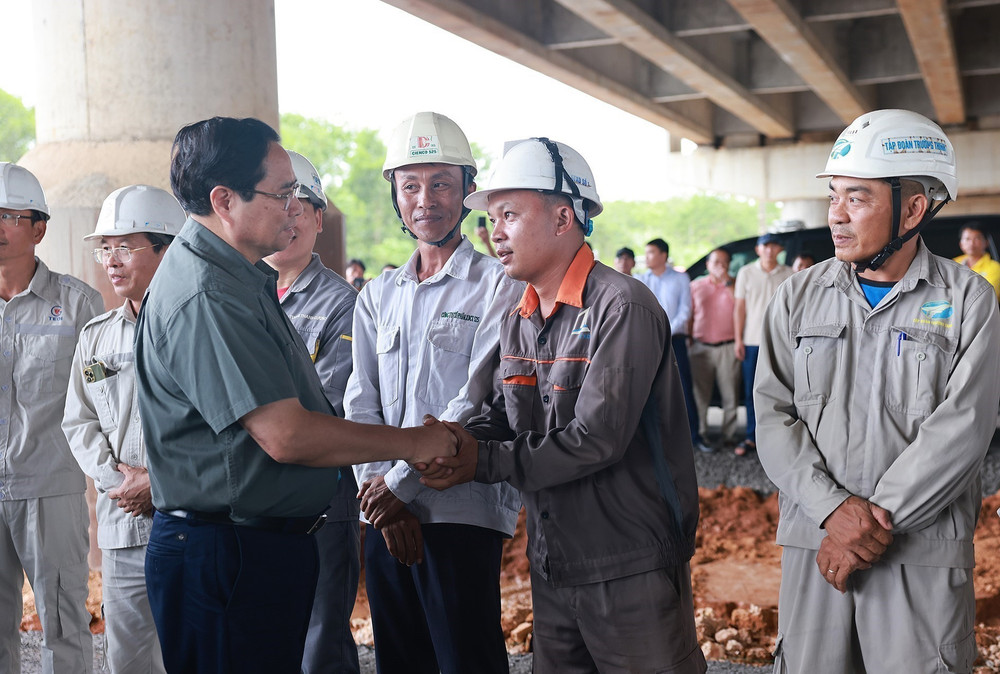 Thủ tướng Phạm Minh Chính với công nhân thi công Dự án đầu tư xây dựng cao tốc Bắc-Nam phía Đông đoạn Vạn Ninh-Cam Lộ. Ảnh: Dương Giang/TTXVN tt2612.jpg