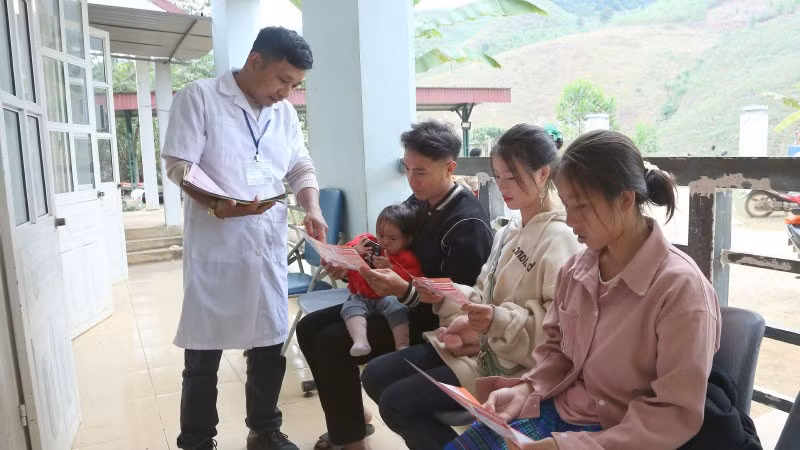 Cán bộ Trạm Y tế Tân Xuân, xã Xuân Nha, phát tờ rơi tuyên truyền về giảm thiểu mất cân bằng giới tính khi sinh.