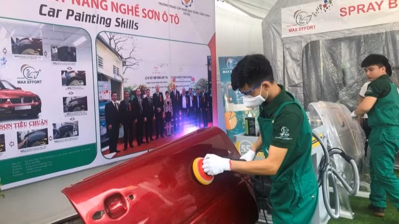Học sinh trình diễn kỹ năng nghề sơn ô-tô. 