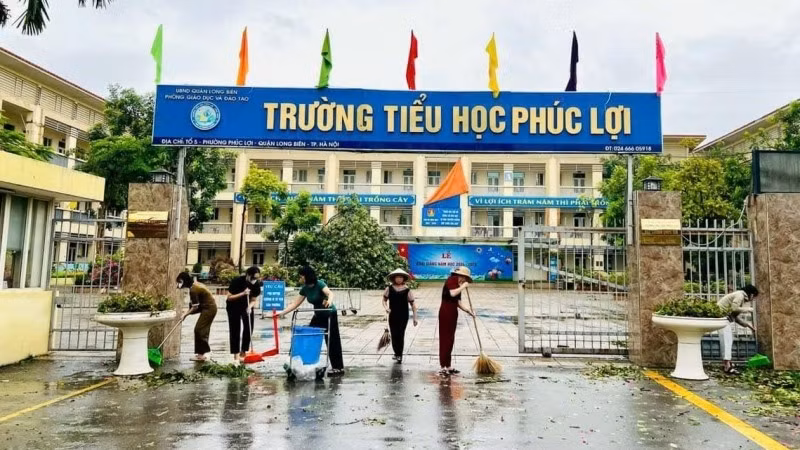 Các giáo viên, cán bộ, nhân viên Trường tiểu học Phúc Lợi dọn dẹp trường học sau đợt bão số 3 năm 2024.