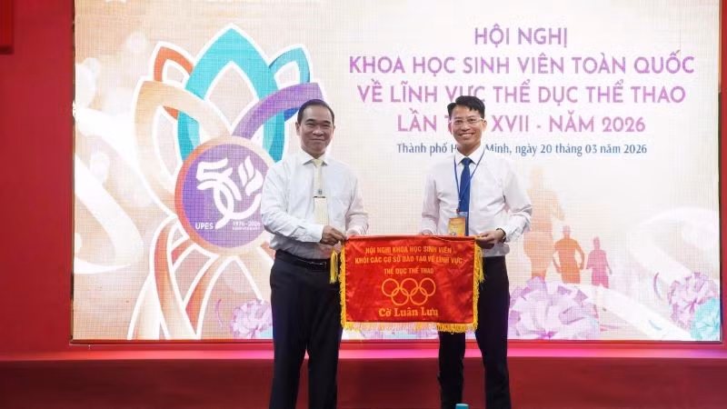 Phó Giáo sư, Tiến sĩ Nguyễn Quang Vinh, Phó Hiệu trưởng Trường đại học Sư phạm Thể dục thể thao Thành phố Hồ Chí Minh trao cờ luân lưu cho Trường đại học Huế, đơn vị đăng cai hội nghị lần thứ XVIII.