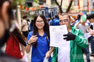 Một người cha đón con gái, xem đề thi của con sau khi kết thúc buổi thi. (Ảnh: ĐẠI THẮNG)